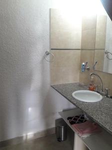 een badkamer met een wastafel en een spiegel bij Complejo Noi Alaia in Valeria del Mar