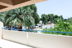 a balcony with a view of a palm tree at Mackenzie Apartment 101 in Larnaka