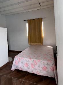 1 dormitorio con 1 cama con colcha rosa en Mogi 2, en Mogi das Cruzes