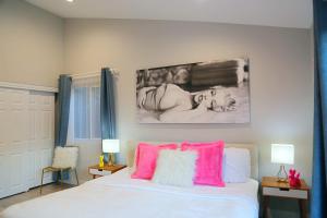 een slaapkamer met een bed met roze en witte kussens bij Casa Marilyn in Palm Springs +52 foto's