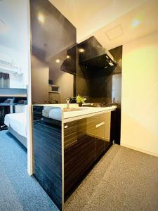 - une cuisine avec évier et un lit dans une chambre dans l'établissement 嵐 Arashi BNB 日本橋 No8111, à Osaka 28 autres photos