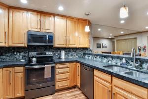 eine Küche mit Holzschränken und Geräten aus Edelstahl in der Unterkunft Adventure Hub-Ski Resorts, Backcountry & Park City 3203 condo in Midway