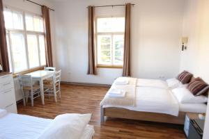 a room with two beds and a table and a desk at Hotel Katrca in Ljubljana