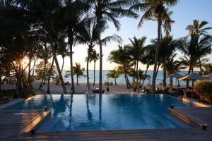 a resort swimming pool with palm trees and the beach at Tiamo Resort in Kemps Bay +28 photos