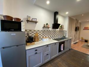 eine Küche mit Kühlschrank und Herd Oberer Backofen in der Unterkunft Maison IDEM in Vouziers