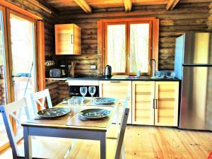 Les FargesMagnifique chalets en rondins avec SPA et Tipis en plaine Nature Environnement ressourçant au calme vue imprenable Lascaux SPA non disponible juillet et aout的配有桌椅和冰箱的厨房