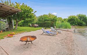 a fire pit and two chairs on a beach at Ferienwohnung Waren Müritz in Waren