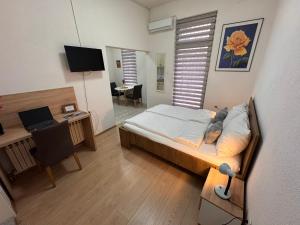 sypialnia z łóżkiem i biurkiem z komputerem w obiekcie Apartments Seyda - 1min from Baščaršija w Sarajewie