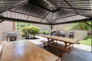 a wooden picnic table under a black umbrella at Rear Ocean View 2 Bedroom Single Level Condo at Kamaole Sands 9-305 in Wailea