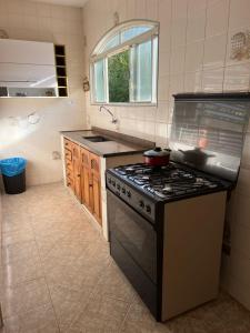 a kitchen with a stove and a sink at Rio quente Casa de Férias in Rio Quente