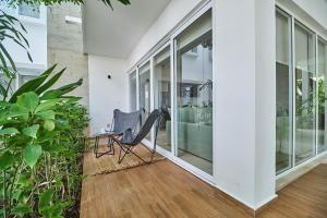 Habitación con puertas de cristal y una silla en el porche. en Aldea Zama Condo with 2 Pools, Gym, Yoga Deck and BBQ Grill, en Tulum 59 fotos más