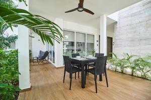 a dining room with a black table and chairs at Zama Condo with 2 Pools, Gym, Yoga Deck and BBQ Grill in Top Location in Tulum +29 photos