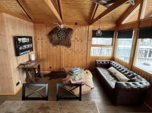 阿克拉内斯Cozy cabin in the woods, only 45 min from the city的配有皮沙发和桌子的客厅