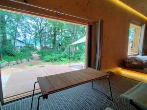 a room with a large window with a bench in front of it at Snow Peak LAND STATION HAKUBA in Hakuba