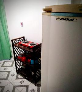 una nevera blanca en una cocina con estantería en Cantinho Esotérico Santo Antônio Salvador, en Salvador