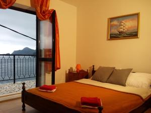 a bedroom with a bed and a large window at Apartments "Villa Mungos" Sobra in Sobra