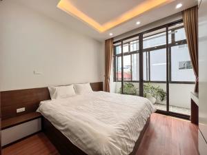 una camera da letto con un letto grande e una grande finestra di NINE HOUSING 49 Linh Lang a Hanoi