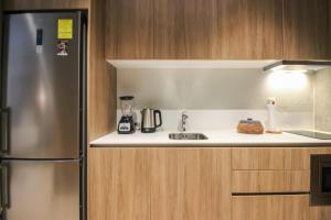 a kitchen with a sink and a refrigerator at Luxury Studio with Rooftop Pool and Gym in Top Location in Tulum