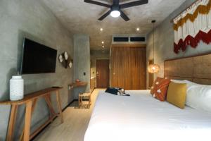 a bedroom with a large bed and a flat screen tv at Luxury Studio with Rooftop Pool and Gym in Top Location in Tulum