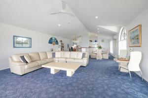 a living room with a couch and a table at Tah Villa 1, 68 Marine Dr - stunning views, linen and air con in Fingal Bay