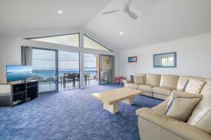 a living room with a couch and a table at Tah Villa 1, 68 Marine Dr - stunning views, linen and air con in Fingal Bay