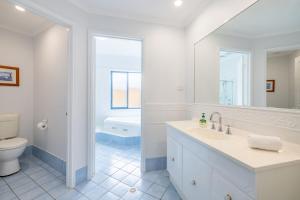 a white bathroom with a sink and a toilet at Tah Villa 1, 68 Marine Dr - stunning views, linen and air con in Fingal Bay +28 photos
