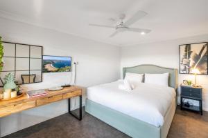 a bedroom with a bed with a desk and a bed sidx sidx sidx at Kiama Mountain Views Studio in Kiama