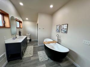 a bathroom with a black and white tub and a sink at Forks Cedar House in Forks +15 photos