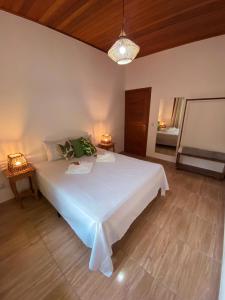 a bedroom with a large white bed in a room at Village da Mata Arraial in Porto Seguro +22 photos