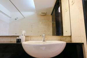 a white sink in a bathroom with a mirror at Homey and Spacious 3BR Apartment at Braga City Walk By Travelio in Bandung +12 photos