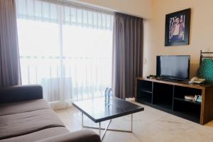 a living room with a couch and a tv at Homey and Spacious 3BR Apartment at Braga City Walk By Travelio in Bandung