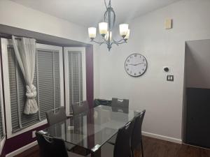 un comedor con una mesa y un reloj en la pared en Peace Stay, en Edmonton