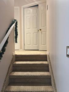 un pasillo con escaleras y una puerta blanca en Peace Stay, en Edmonton