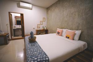 a bedroom with a large white bed and a mirror at Sleepy House Chiang Rai in Chiang Rai