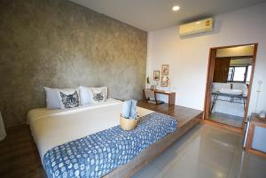 a bedroom with a large bed with a basket on a bench at Sleepy House Chiang Rai in Chiang Rai