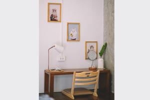 a desk with a chair and pictures on the wall at Sleepy House Chiang Rai in Chiang Rai