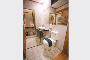 a bathroom with a toilet and a sink at Sleepy House Chiang Rai in Chiang Rai