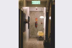 a hallway with a table and a chair in a room at Sleepy House Chiang Rai in Chiang Rai