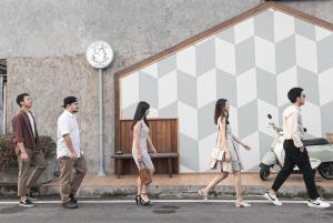 a group of people walking down a street at Sleepy House Chiang Rai in Chiang Rai