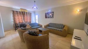 a living room with couches and chairs and a table at Résidence Nopeli in Cotonou