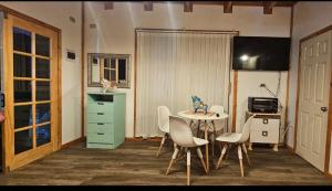 a room with a desk and a table and chairs at Tiny house in Coñaripe