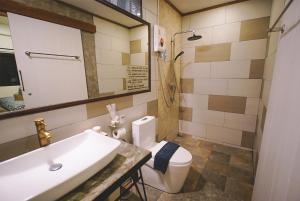 a bathroom with a sink and a toilet and a mirror at Sleepy House Chiang Rai in Chiang Rai