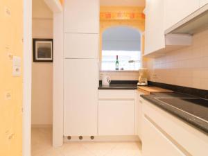 a kitchen with white cabinets and a sink and a window at Studio in Ostend with Stunning Sea Views in Ostend +32 photos