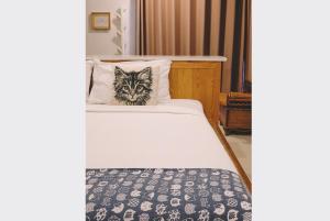 a cat sitting on top of a bed at Sleepy House Chiang Rai in Chiang Rai