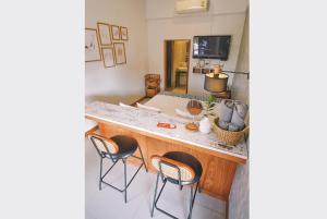 a kitchen with a counter with chairs and a counter top at Sleepy House Chiang Rai in Chiang Rai
