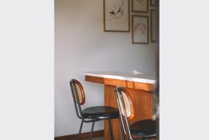 a room with two chairs and a table with a counter at Sleepy House Chiang Rai in Chiang Rai