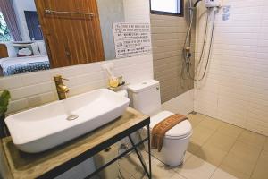 a bathroom with a sink and a toilet at Sleepy House Chiang Rai in Chiang Rai