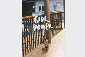 a cat standing next to a gate with the words girl power at Sleepy House Chiang Rai in Chiang Rai