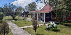 uma pequena casa com um jardim em frente em Volcano View Cottage em Volcán