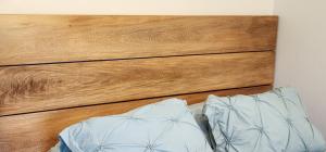 uma cama com cabeceira de madeira e dois travesseiros em Volcano View Cottage em Volcán